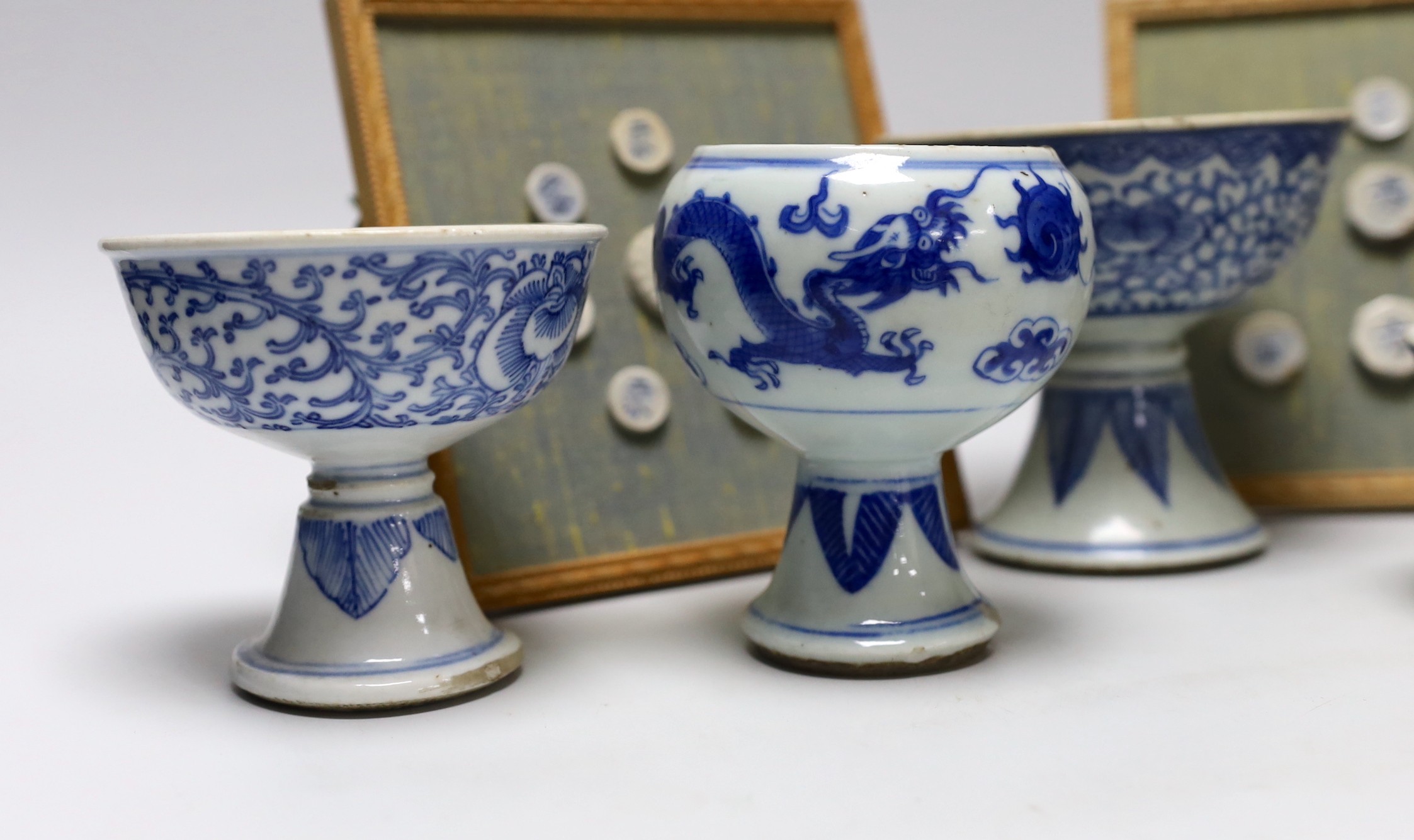 Five 19th century Chinese blue and white stem cups and two framed sets of Thai gaming counters, tallest cup 11cm